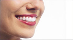 Woman with invisalign braces in her mouth smiling